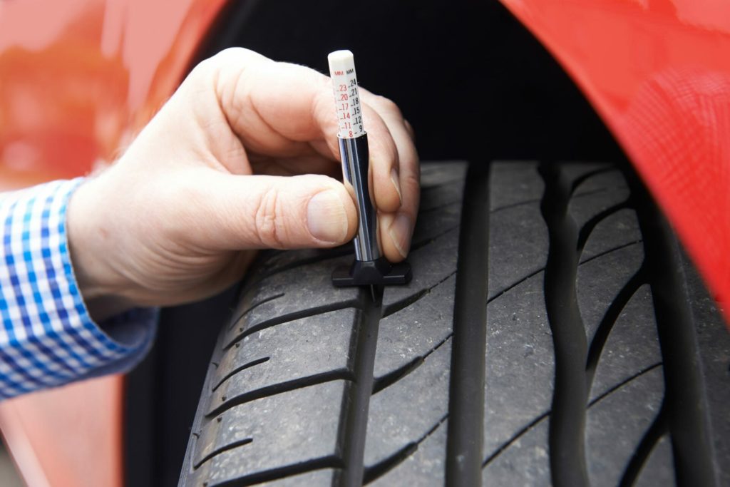 man checking health of tire
