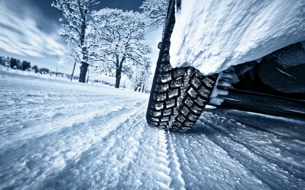 Car with winter tires driving on a snowy road